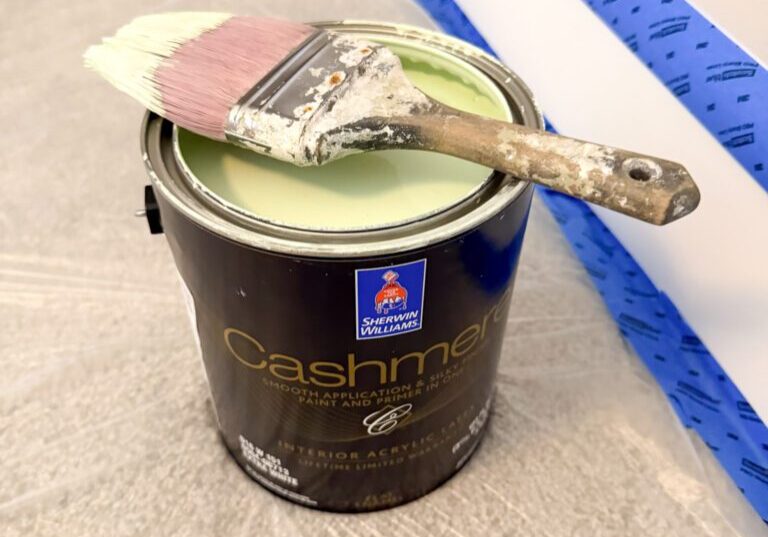 Open light green paint can with brush